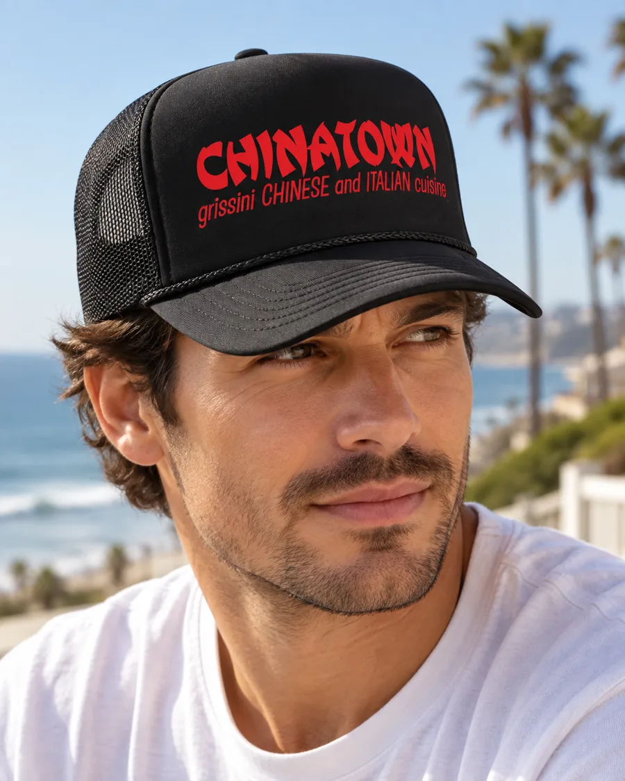 Man wearing a black trucker hat reading “Chinatown — grissini Chinese and Italian cuisine” in red